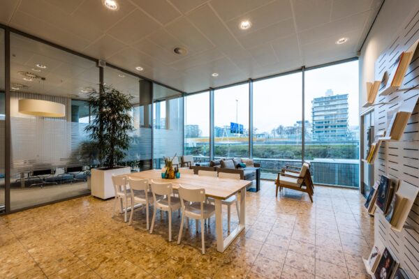 Moderne kantoorruimte aan de Burgemeester Rijnderslaan met vergaderruimte, zithoek en grote ramen met uitzicht op de stad.